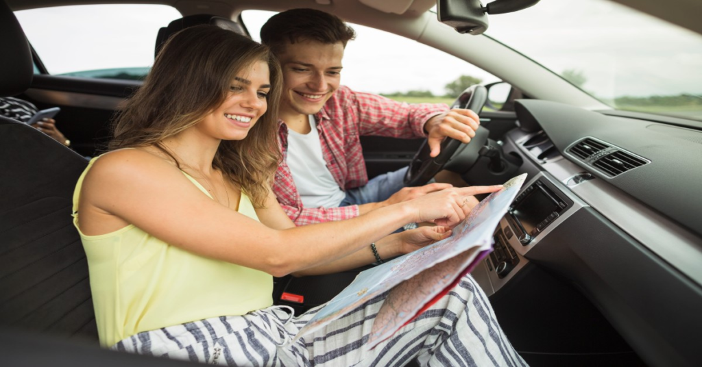 Couple navigating a road trip in a rental car